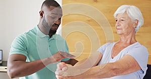 Video of happy african american male physiotherapist exercising with caucasian senior woman