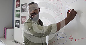 Video of happy african american male teacher at blackboard during math lesson