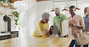 Video of happy african american parents with daughter and grandparents, arriving home with shopping