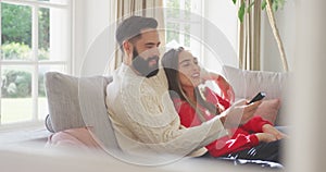 Video of happy caucasian couple siting on sofa and watching tv
