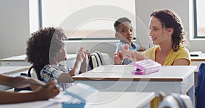 Video of happy caucasian female teacher learning math to african american boy