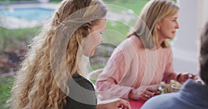 Video of happy caucasian mother turning and smiling at outdoor family dinner table