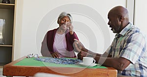 Video of happy senior african american couple doing puzzles