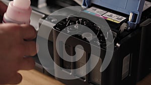 Video instruction, technology, media, office, stationery concept - close-up of male hands preparing new inkjet printer