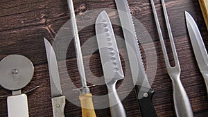 Video of knifes and sharpening tools placed on table in a row, honing rod and sanding whetstone, close up video clip, 4k