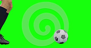 Video of legs of caucasian male soccer player kicking ball on green screen background