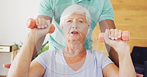 Video of midsection of african american male physiotherapist exercising with caucasian senior woman