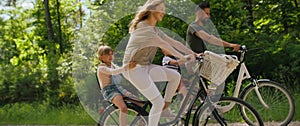 Video of playful family having fun on a bicycles in the woods.