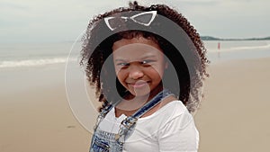 Video portraits, An African-American girl who smiles and scowl faces on the beach.