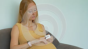 In this video, a pregnant woman is seen measuring her oxygen levels using a pulse oximeter.