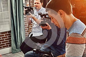 Video production backstage. Behind the scenes of creating video content, a professional team of cameramen with a