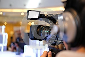 video production camera recording live event on stage. television social media broadcasting seminar conference.