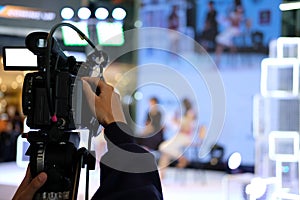 video production camera recording live event on stage. television social media broadcasting seminar conference.