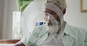 Video of sad african american senior man sitting alone