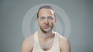 Video of serious unshaved man on gray background