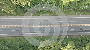 The video shows a drone slowly flying from right to left, capturing a wide road.