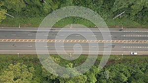The video shows a drone slowly flying from right to left, capturing a wide road