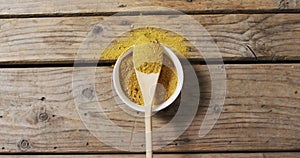 Video of spoon with tumeric seasoning lying on wooden surface