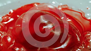 Video of sticky bubbled red liquid, close-up