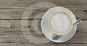 Video of white cup of coffee with milk over wooden background