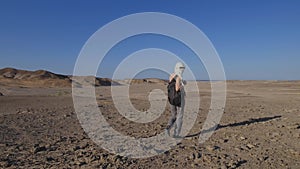 In this video, a woman explores the vast expanse of the Egyptian desert.