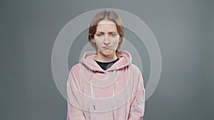 Video of young confused woman in pink sweatshirt