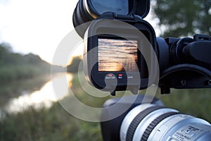 A videocamera filming river