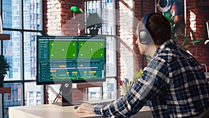 Videographer doing video montage using specialized software on green screen PC