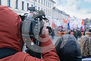Videographer is reporting from a city street during a mass political action