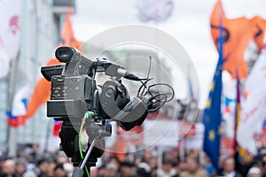 Videographer`s camera is reporting from a city street during a mass political action