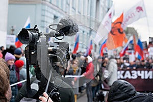 Videographer`s camera is reporting from a city street during a mass political action