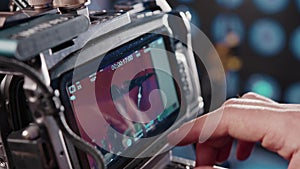 Videographer set a frame for video shooting and adjusts the camera on screen