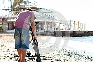 Videographer with tripod camera in documentary film shooting