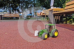 Abandoned green toy tractor in the playground in Vidnoe