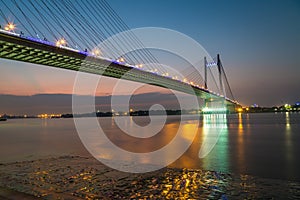 Vidyasagar bridge (setu) on river Ganges at twilight with city lights reflections.