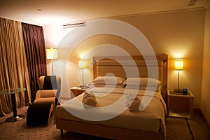 VIENNA, AUSTRIA - APR 30th, 2017: King sized bed in a luxury hotel room with an lounge chair at the Penthouse Suite at