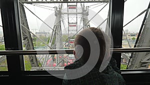 In Vienna, Austria from the window booths of the ferris wheel little boy looks at the city