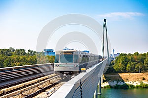 Vienna metro train passing a bridge over Danube river