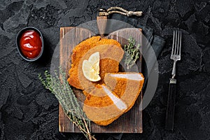 Viennese veal escalope, fried meat Schnitzel steak. Black background. Top view