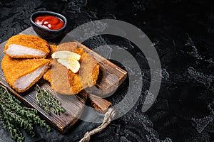 Viennese veal escalope, fried meat Schnitzel steak. Black background. Top view. Copy space