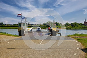 View on car passenger ferry over river Maas to limburg village Bergen