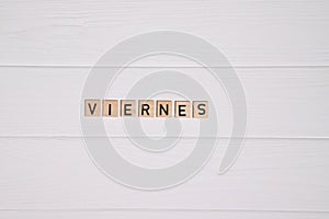 Viernes week day name on white wooden background photo