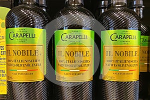 Closeup of bottles italian Casa Olearia Carapelli Il Nobile olive oil in shelf of german supermarket