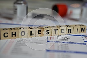 Closeup of word cholesterin on laboratory requisition slip with syringe and vial