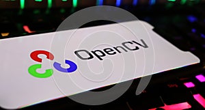 Closeup of smartphone screen with logo lettering of OpenCV library on computer keyboard
