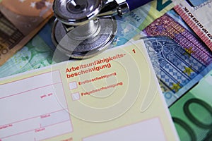 VIERSEN, GERMANY - MAY 20. 2019: Inability to work cost concept - Stethoscope and yellow certificate of incapicity German: