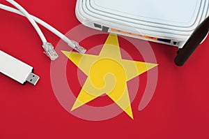 Vietnam flag depicted on table with internet rj45 cable, wireless usb wifi adapter and router. Internet connection concept