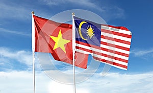 Vietnam flag and Malaysia flag on cloudy sky photo