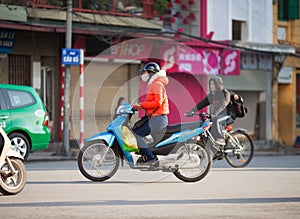 Vietnam, Hanoi. Young woman rides on motorbike