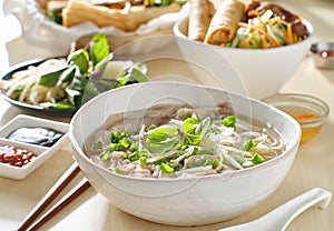 Vietnamamese meal with beef pho bo soup accompanied by hoisin sauce and sriracha photo